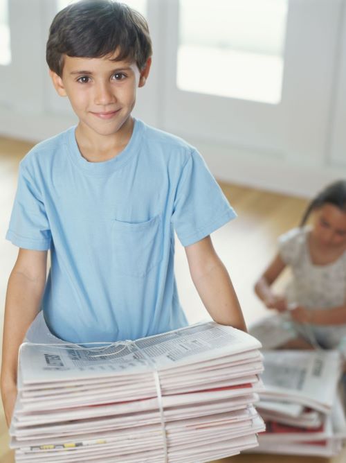 child holding newspapers