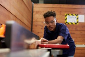 Teen worker using table saw