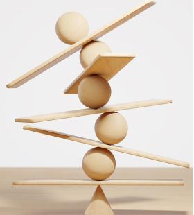Boards and spheres balancing on top of each other balancing on a cone. 