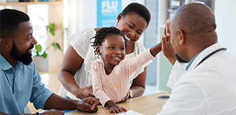 Two parents and their young doctor talking to a child care provider.