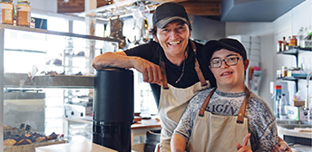 Two worker, one with a disability, working together in a workshop.