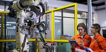 Two students working with robotic equipment 