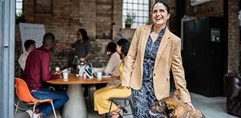 A blind woman smiling with her service dog.