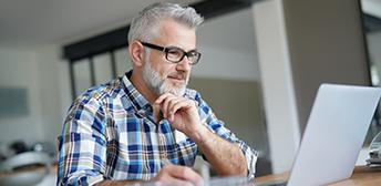 A man looking at resources for seasonal layoffs on this computer