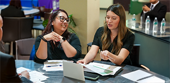 Two women sitting in a mock interview.