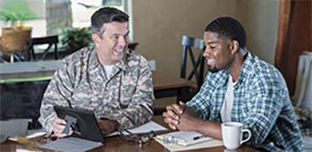 A man in the military assisting a veteran with Texas Veteran Leadership Program resources. 