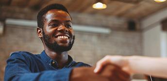  A man shaking a hand at a job interview.