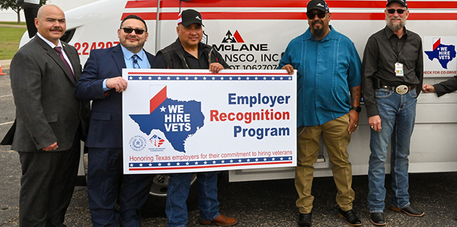 A group of employers holding a We Hire Vets recognition sign. 