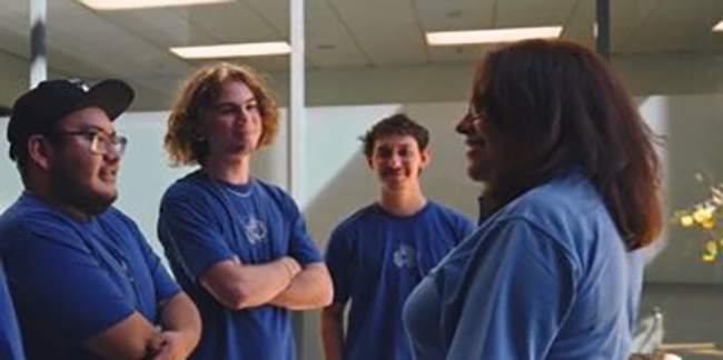 Woman talking to a group of apprentices.