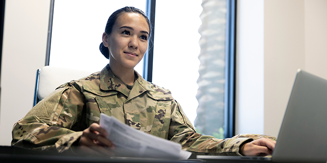Woman in uniform using laptop.