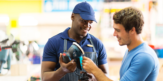 An employee showing a customer a tool.