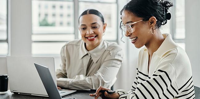 Two women looking at a computer at a training.