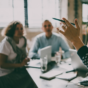A group of people listening to a speaker in an office setting.